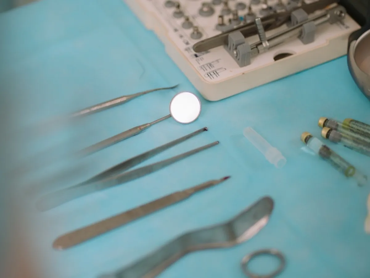Kit de implante odontológico com fresas e instrumental cirúrgico organizados sobre a bandeja, prontos para o procedimento planejado.