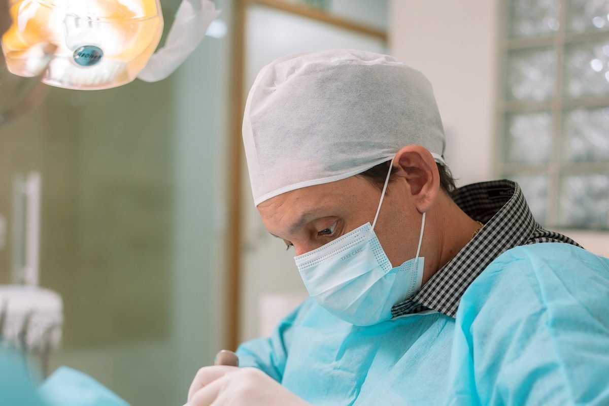 Dr. Reinaldo José Seco em procedimento odontológico de precisão, no consultório da Zona 8, em Maringá.